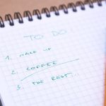 Handwritten to-do list on graph paper notebook with pen. Ideal for organizing tasks.
